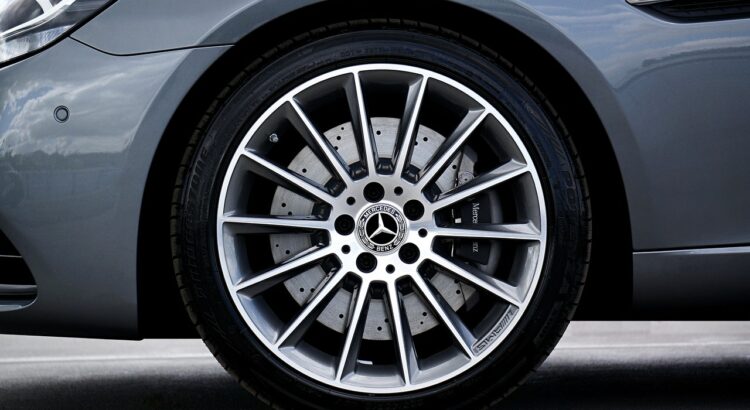 La taille des pneus. Une voiture gris avec un pneu neuf monté