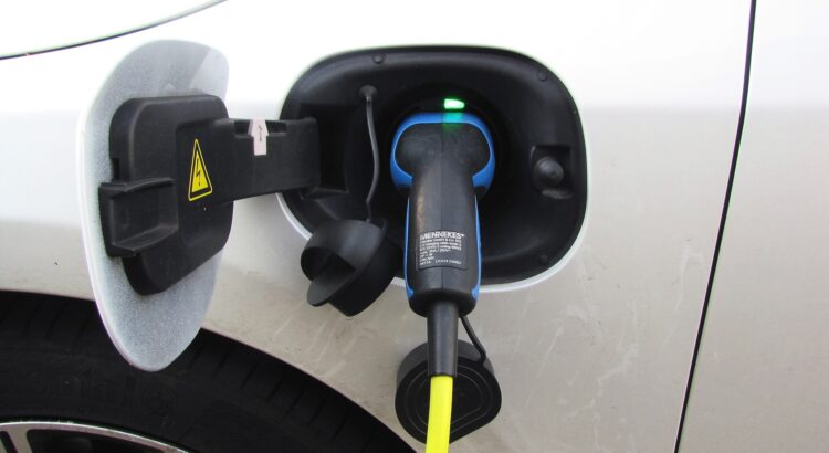 Une voiture électrique en train de se charger. Elle porte un pneu voiture électrique