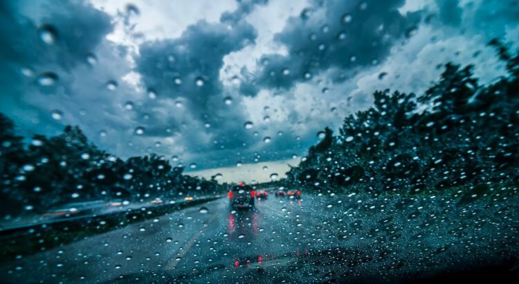 Comment conduire sous la pluie. Des gouttes d'eau qui tombent sur la vitre de la voiture